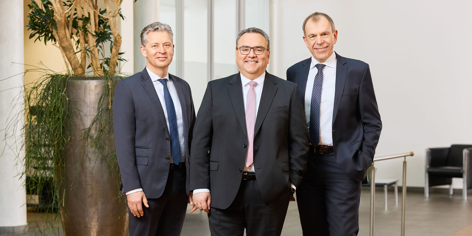 Die drei Vorstände der Sparkasse Freiburg in repräsentativer Büroumgebung.