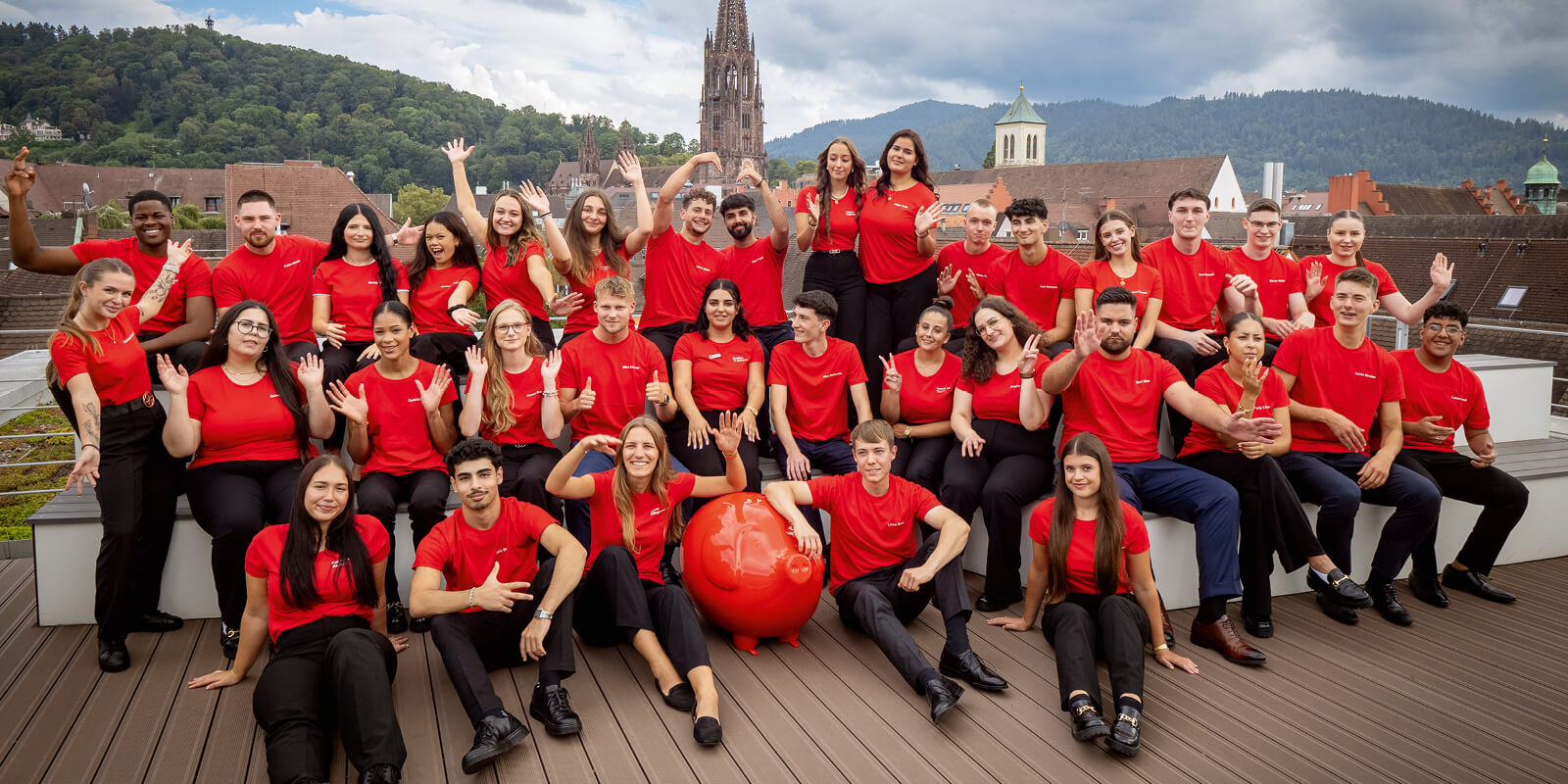 Neue Auszubildende 2024 der Sparkasse Freiburg vor Münster-Kulisse