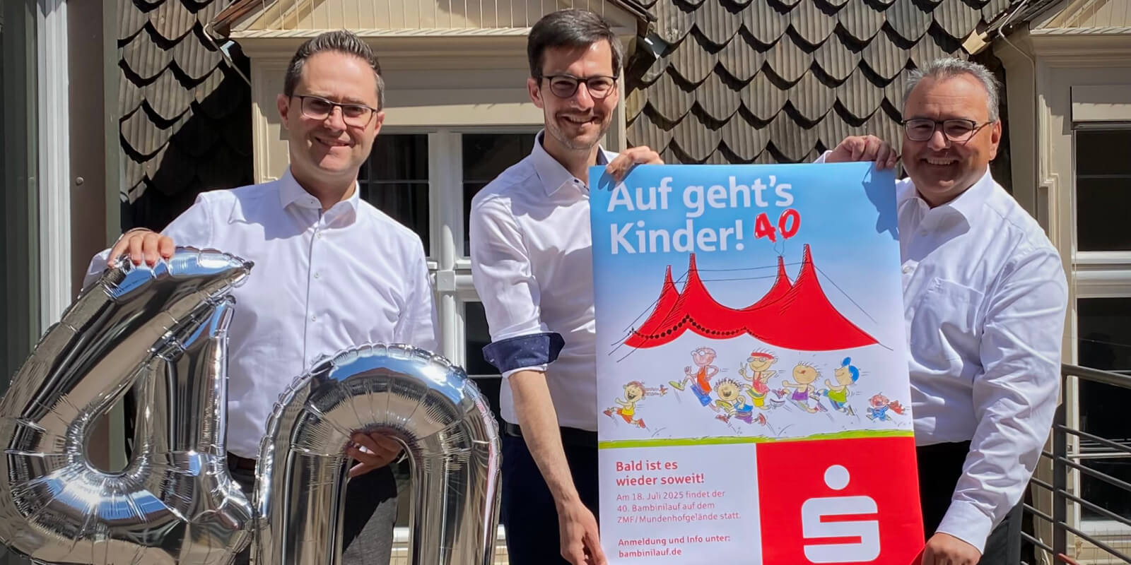 Marc Winsheimer, Martin Horn und Daniel Zeiler werben Luftballons und Plakat für den 40. Sparkassen-Bambinilauf in Freiburg