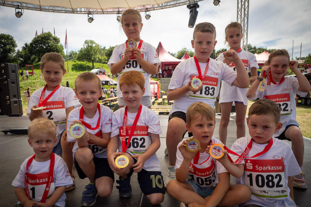 Kinder mit Medaillen auf der Bühne beim 40. Bambinilauf 2025 auf dem Mundenhof in Freiburg