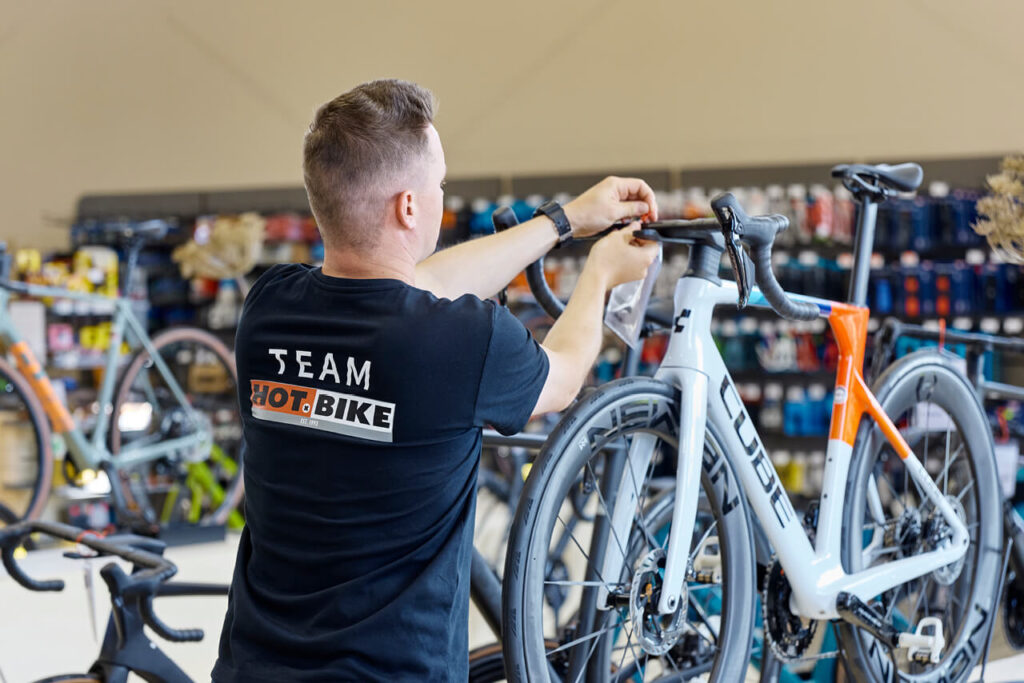 Sebastian Meyer von HOT.BIKE justiert das Cockpit eines Rennrads im Verkaufsraum des Fahrradladens.