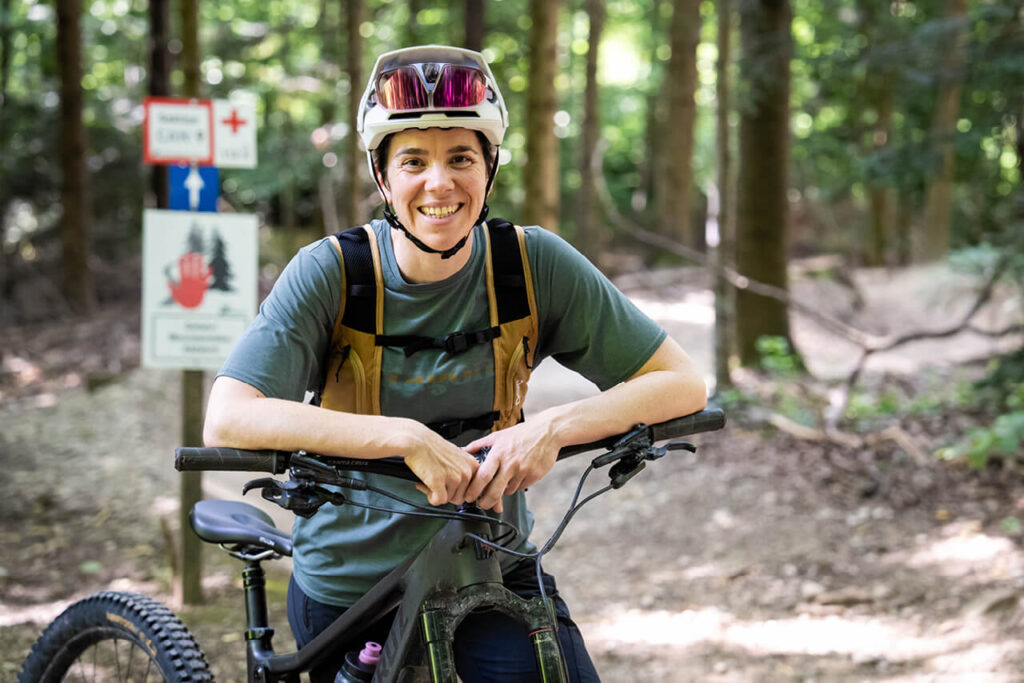 Lena Kehry, Trainerin und Zweite Vorsitzende von MTB Freiburg, mit Fahrrad auf Waldtrail – engagiert für Fairness, Technik und Naturerlebnis im Verein.