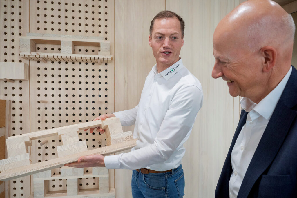 Matthias Eckert von Lignotrend zeigt Frank Wittner von der Sparkasse Freiburg-Nördlicher Breisgau ein Holzelement.