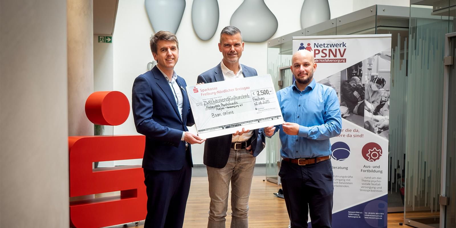 Alexander Jacobs von der Sparkasse übergibt Michael Steil und Jonas Engesser vom Netzwerk PSNV einen Spendenscheck über 2.500 Euro für die Lernplattform 8SAM-ONLINE.DE.