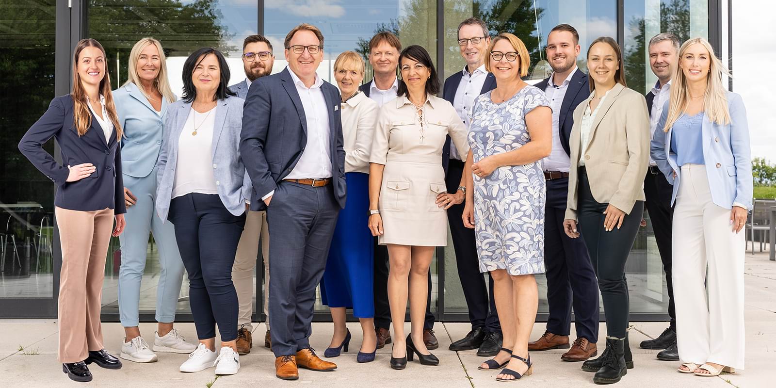 Team der S-Immobilien vor einem modernen Glasgebäude